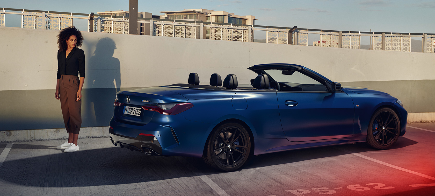 Tričetrtinski pogled od zadaj, BMW M440i xDrive Cabrio, G23, 2020 BMW M440i xDrive Cabrio, G23, 2020, lakiranje BMW Individual v kovinski barvi Frozen Portimao Blue, tričetrtinski pogled od zadaj z manekenko