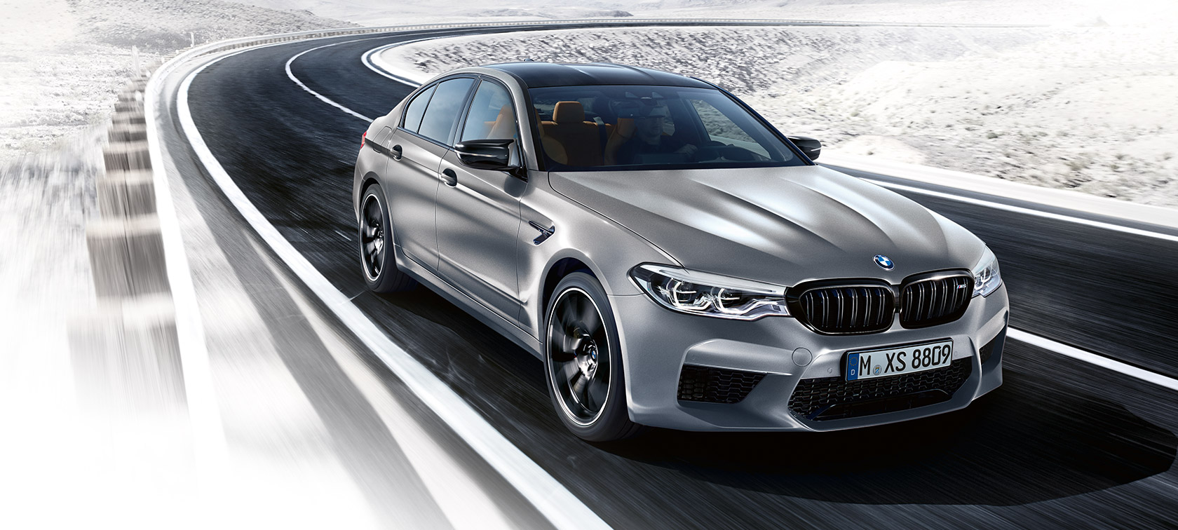 Oblikovni poudarki. BMW M5 Competition, tričetrtinski posnetek od spredaj med vožnjo.