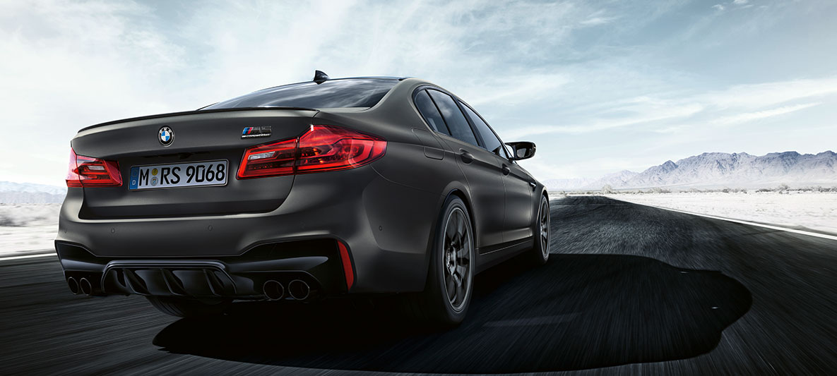 Izpušne cevi. BMW M5 Edition 35 Jahre, tričetrtinski posnetek zadka med vožnjo.