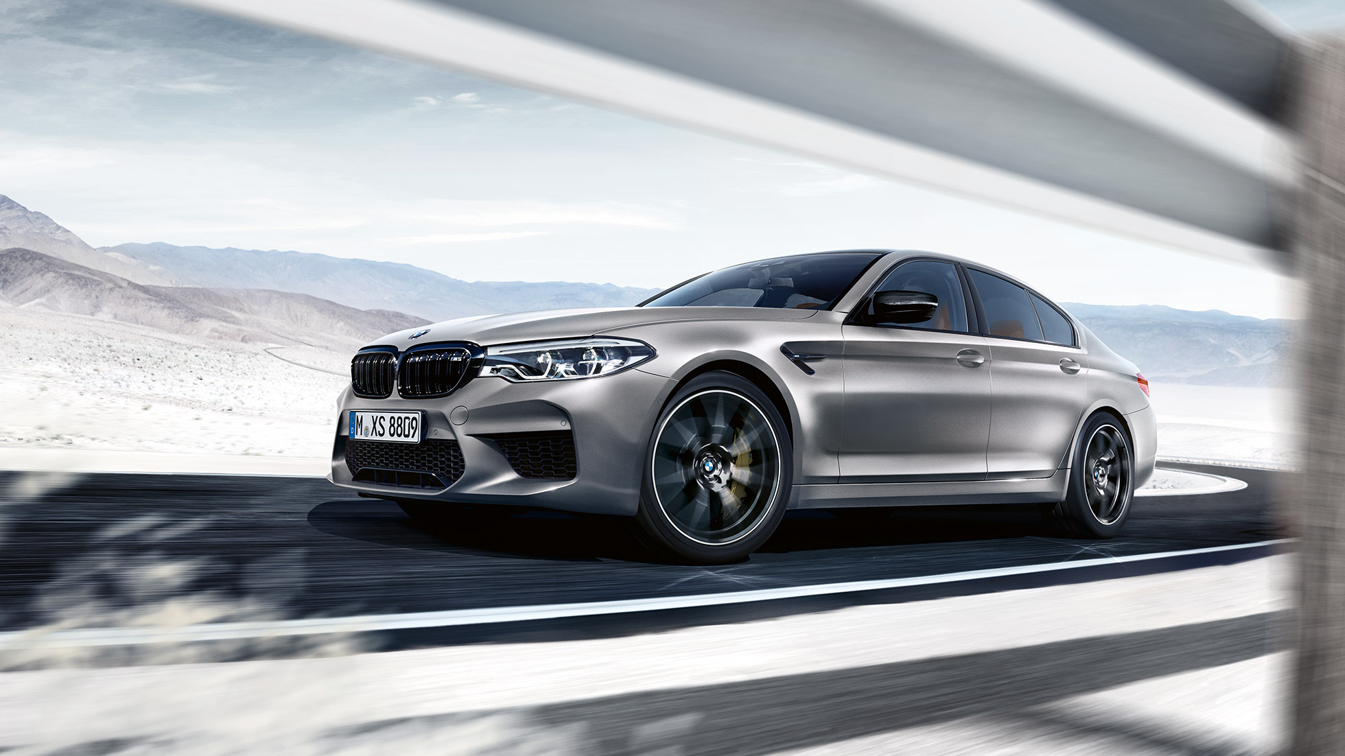 M xDrive. BMW M5 Competition, tričetrtinski posnetek od spredaj med vožnjo.