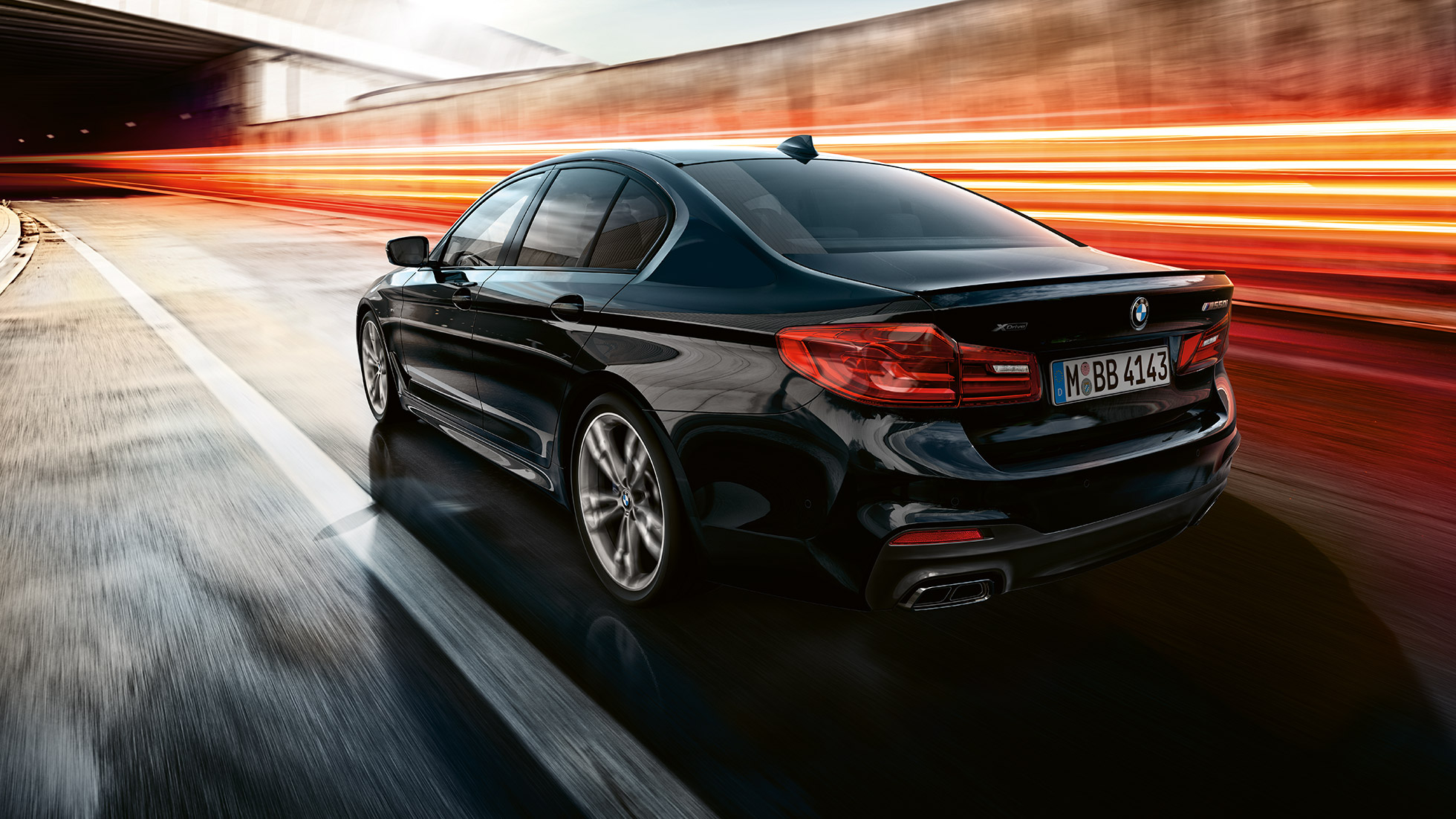 Vozna dinamika. BMW M550i in BMW M550d, tričetrtinski posnetek zadka med vožnjo.