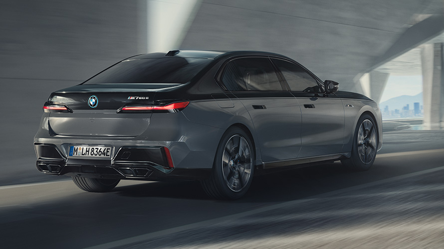 BMW M760e xDrive Limuzina, G70, paket M Performance BMW M760e xDrive Limuzina, G70, paket M Performance, dvobarvno lakiranje BMW Individual v kovinski barvi Black Sapphire, lakiranje BMW Individual v kovinski barvi Dravite Grey, tričetrtinski pogled od zadaj med vožnjo