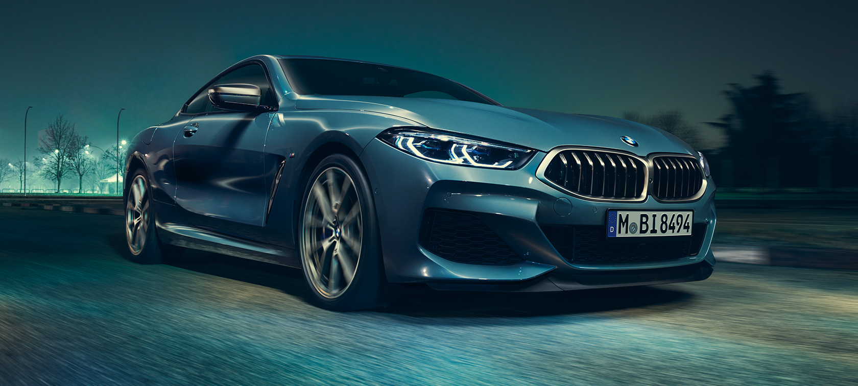 BMW M850i xDrive Coupé, v sprednjem polprofilu. BMW M850i xDrive Coupé v kovinski barvi Barcelona Blue, med vožnjo, v sprednjem polprofilu.