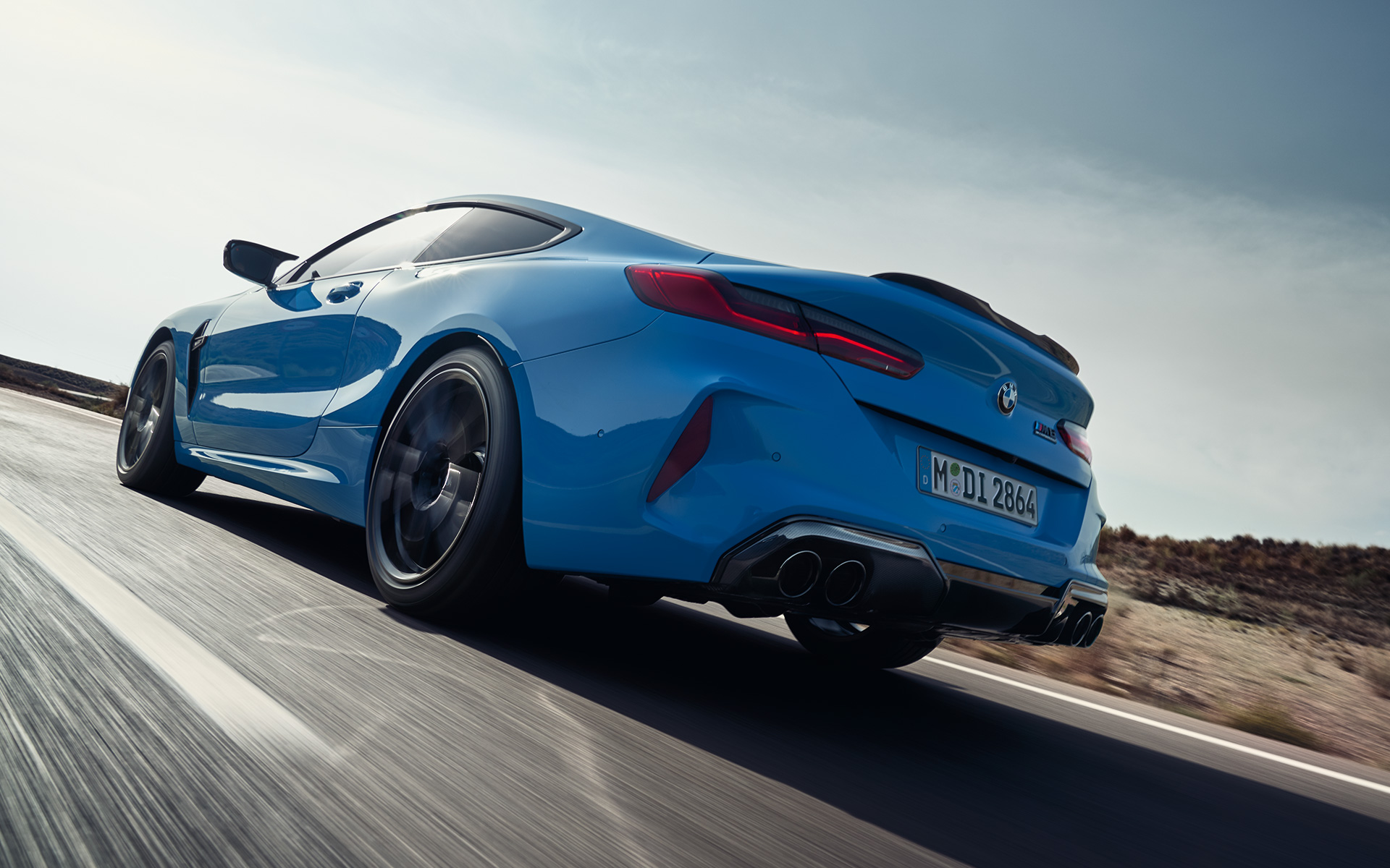 BMW M8 Competition Coupé, F92, LCI, osvežitev 2022, nekovinska barva Daytona Beach Blue, tričetrtinski pogled od zadaj med vožnjo po avtocesti