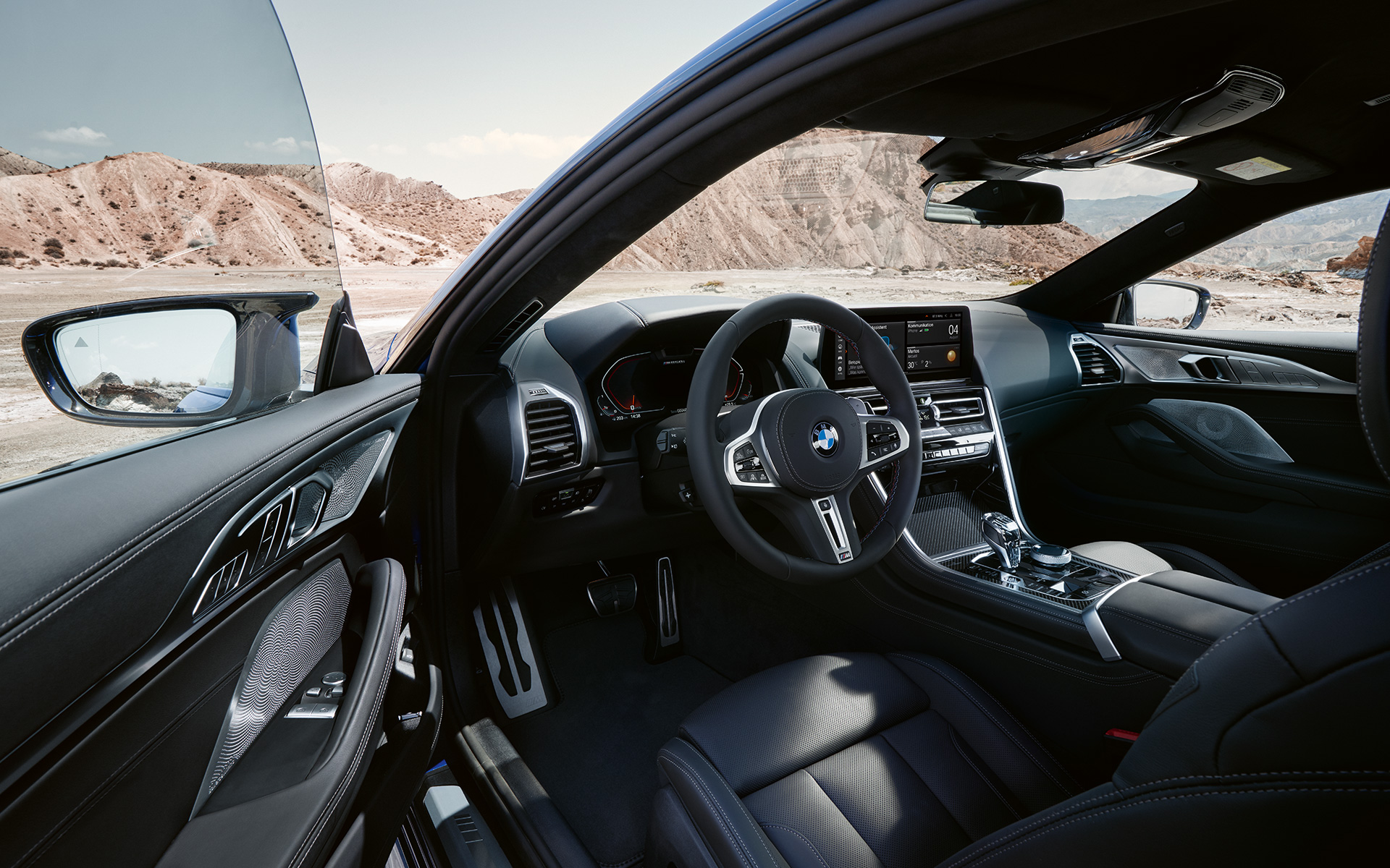 BMW M850i xDrive Coupé, G15, LCI, osvežitev 2022, kokpit, usmerjen k vozniku z M usnjenim volanom pri odprtih vratih