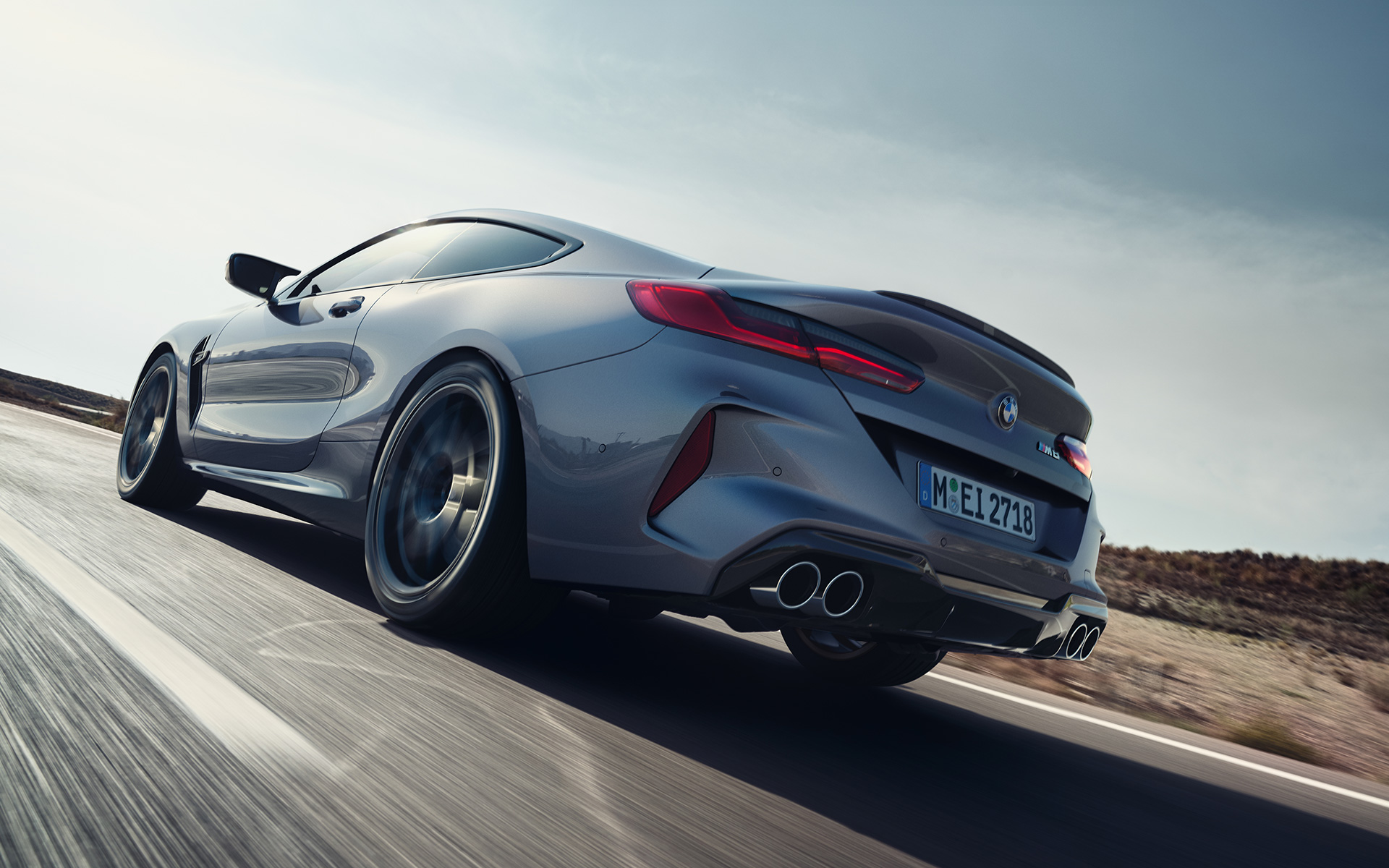 BMW M8 Coupé, F92, LCI, osvežitev 2022, kovinska barva Skyscraper Grey, tričetrtinski pogled od zadaj med vožnjo po avtocesti, posnetek pod nizkim kotom