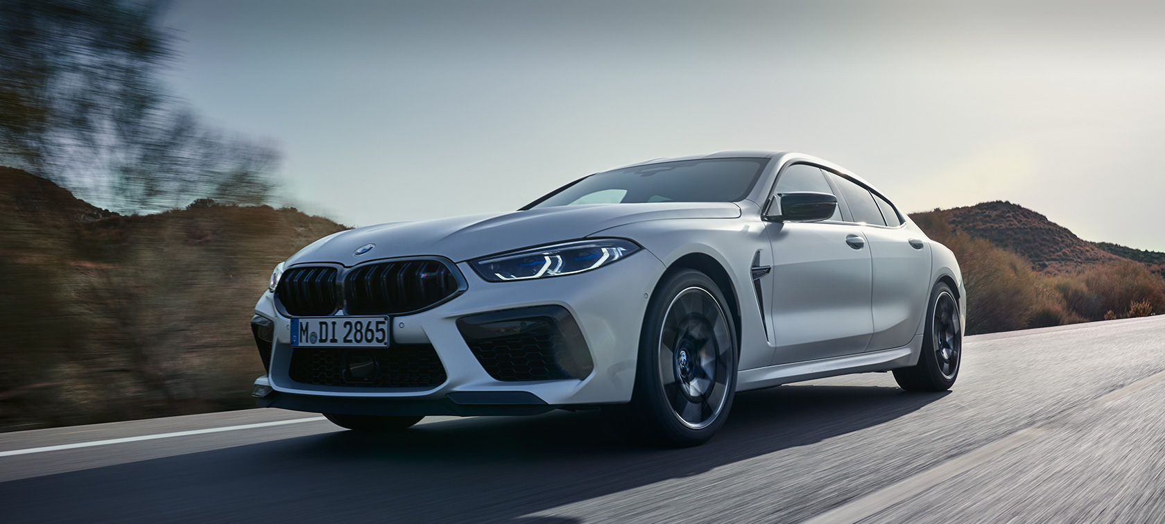 BMW M8 Competition Gran Coupé, F93, LCI, osvežitev 2022, lakiranje BMW Individual v kovinski barvi Frozen Brilliant White, tričetrtinski pogled od spredaj med vožnjo