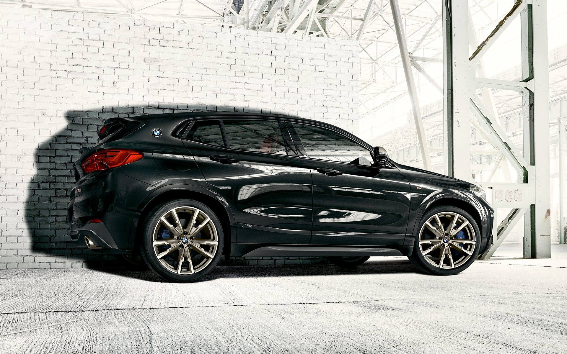 BMW X2 M35i, F39, kovinska barva Sapphire Black, M platišča iz lahke zlitine, stranski pogled med mirovanjem