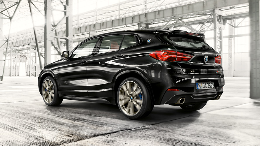 BMW X2 M35i, F39, kovinska barva Black Sapphire, tričetrtinski pogled od zadaj med vožnjo BMW X2 M35i, F39, kovinska barva Black Sapphire, tričetrtinski pogled od zadaj med vožnjo