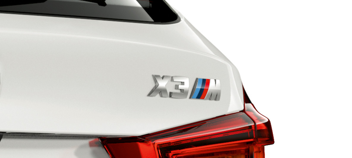 BMW X3 M, oznaka modela. BMW X3 M v barvi Alpine White, zunanjost, zadnji del z oznako modela.