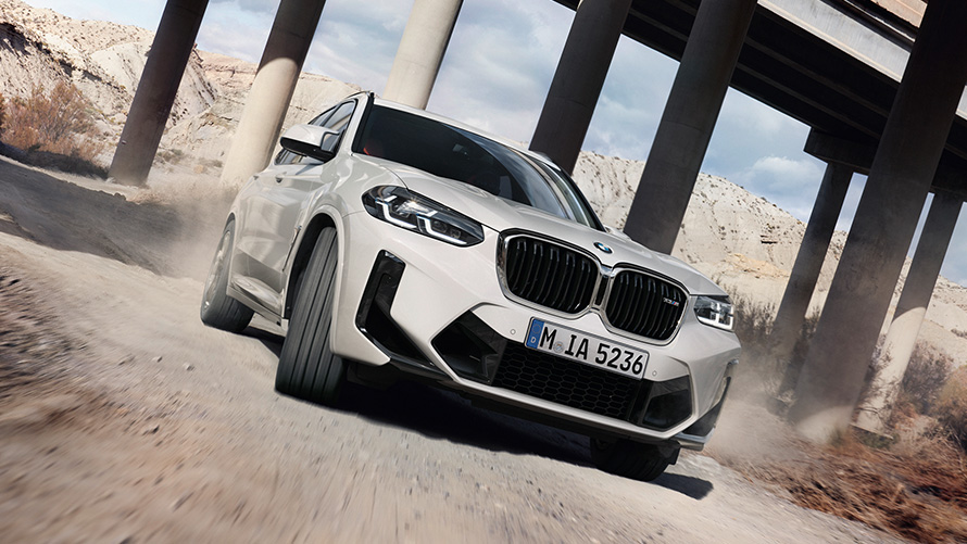 BMW X3 M, F97, LCI, osvežitev 2021, tričetrtinski pogled od spredaj med vožnjo skozi ovinek BMW X3 M, F97, LCI, osvežitev 2021, barva Alpine White, tričetrtinski pogled od spredaj med vožnjo skozi ovinek