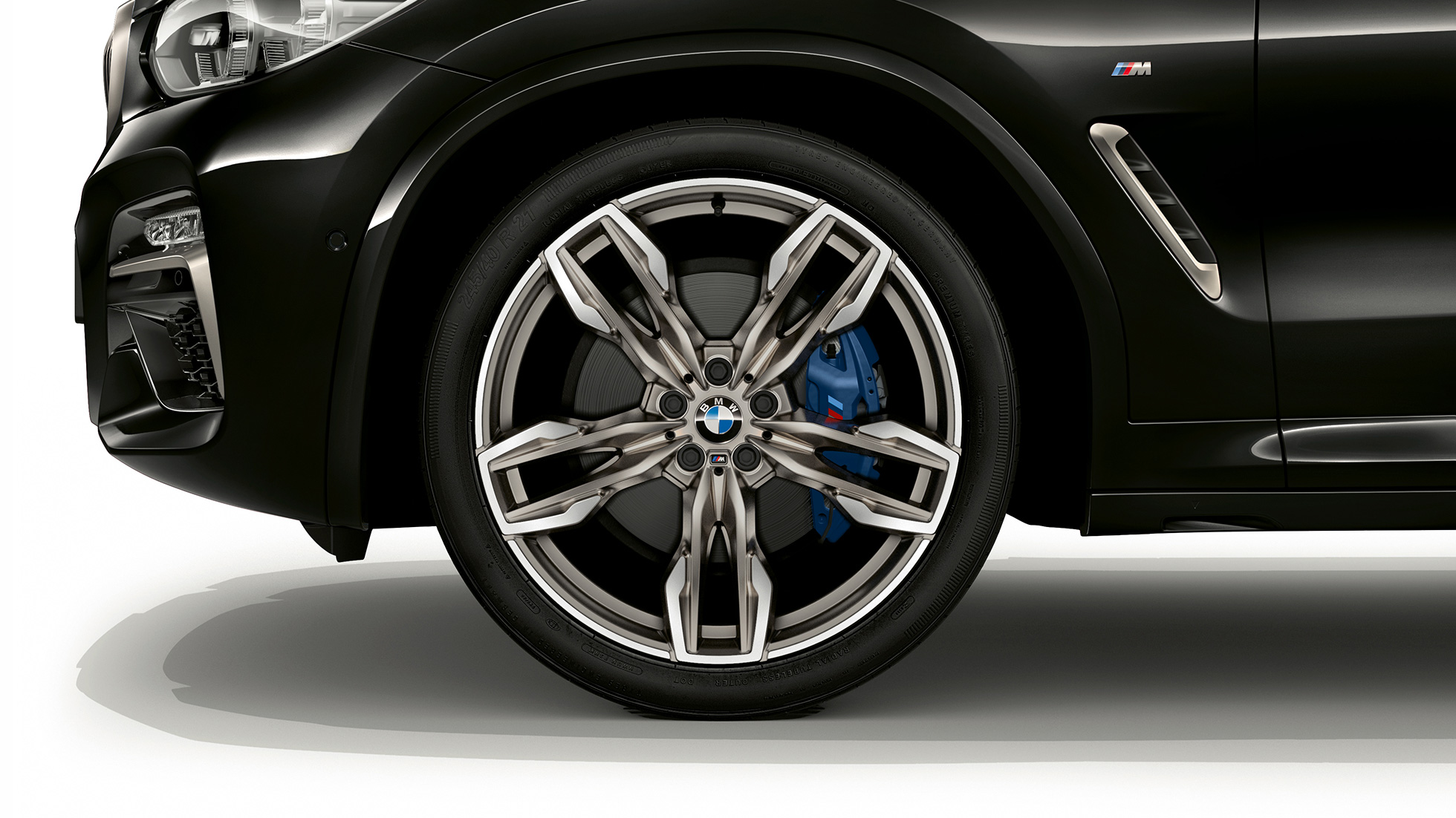 BMW X4 M40i in BMW X4 M40d, 21-palčna lita aluminijasta platišča M. BMW X4 M40i in BMW X4 M40d v kovinski barvi Black Sapphire, zunanjost, pogled s strani na 21-palčna lita aluminijasta platišča M z dvojnimi naperami.