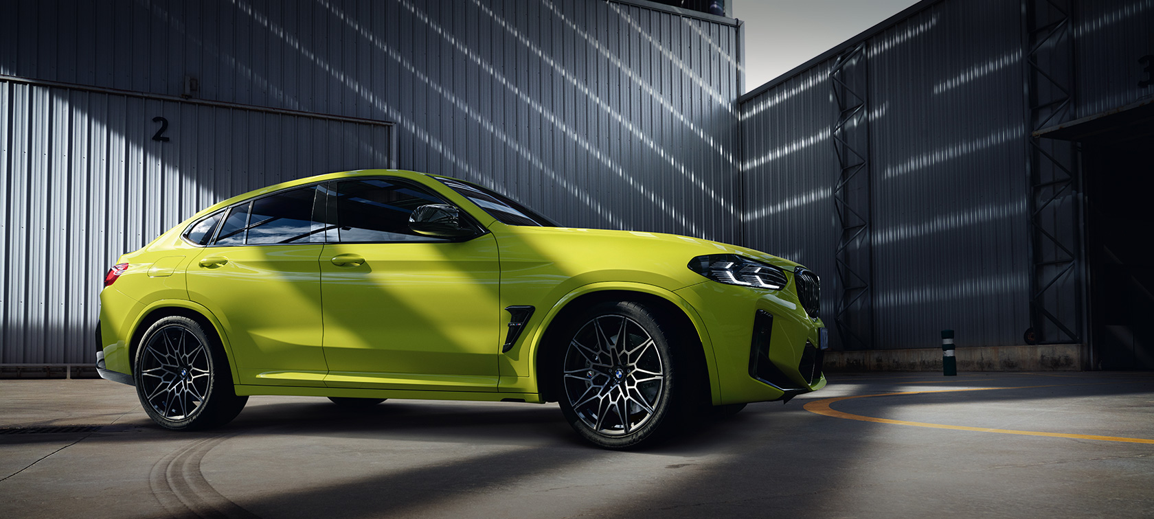 BMW X4 M Competition, F98, LCI, osvežitev 2021, barva Sao Paulo Yellow, stranski pogled v hali