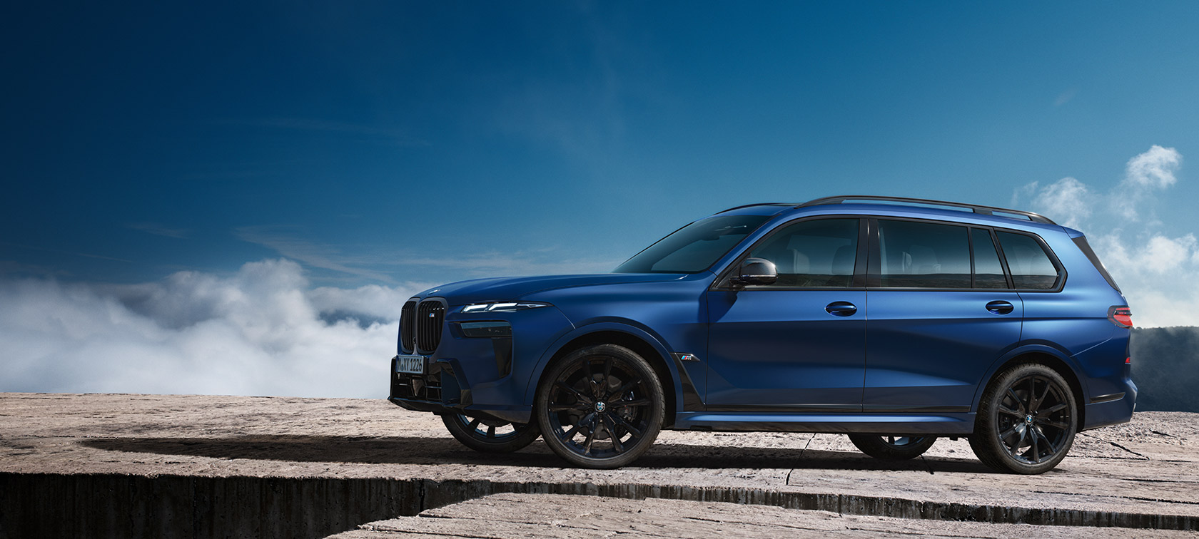BMW X7 M60i xDrive G07 LCI Frozen Marina Bay Modri stranski pogled, pred gorsko pokrajino