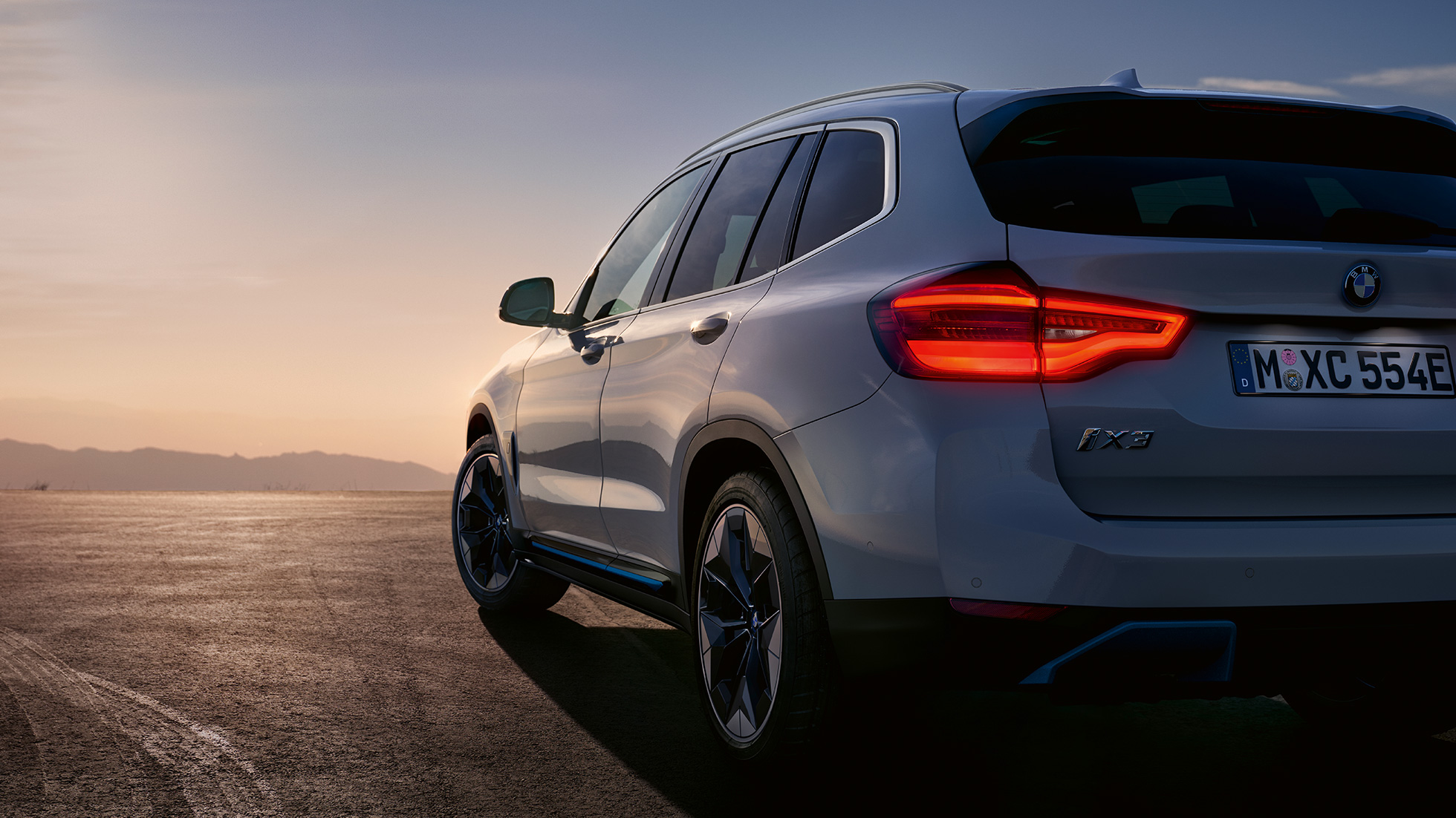 BMW iX3, G08, tričetrtinski pogled od zadaj na cesti BMW iX3, G08, 2020, kovinska barva Mineral White, tričetrtinski pogled od zadaj na cesti