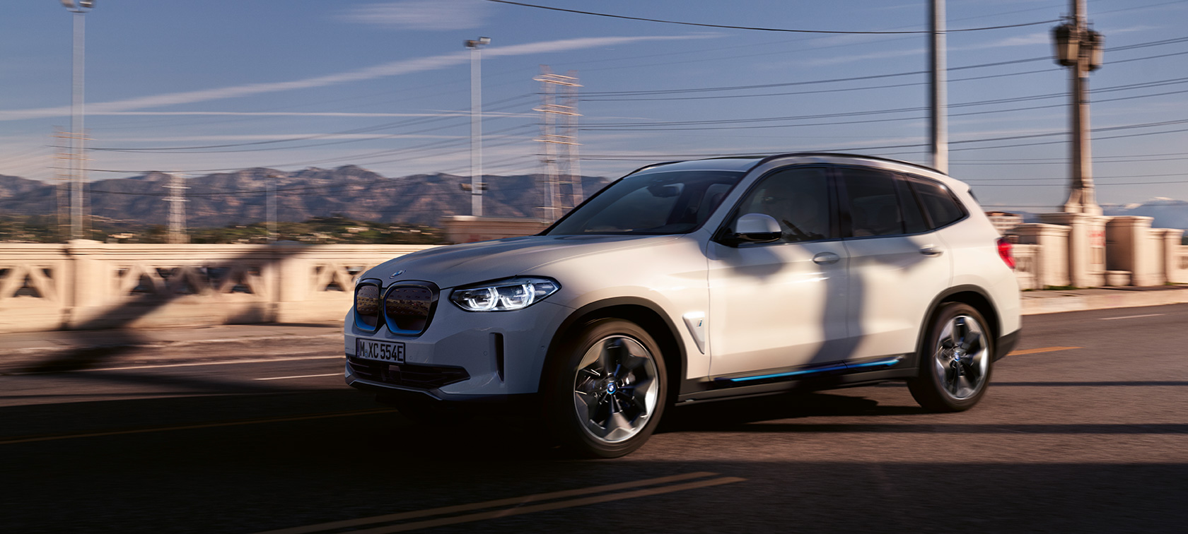 BMW iX3, G08, tričetrtinski pogled od spredaj, vožnja po cesti BMW iX3, G08, 2020, kovinska barva Mineral White, tričetrtinski pogled od spredaj, vožnja po cesti