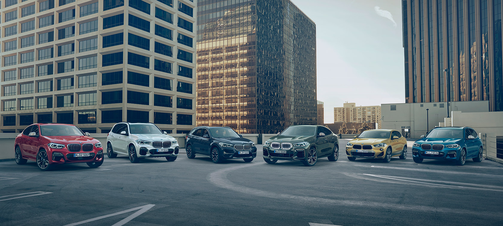Vozila BMW X na parkirni ploščadi pred stavbami BMW serije X, vozila BMW X na parkirni ploščadi pred stavbami
