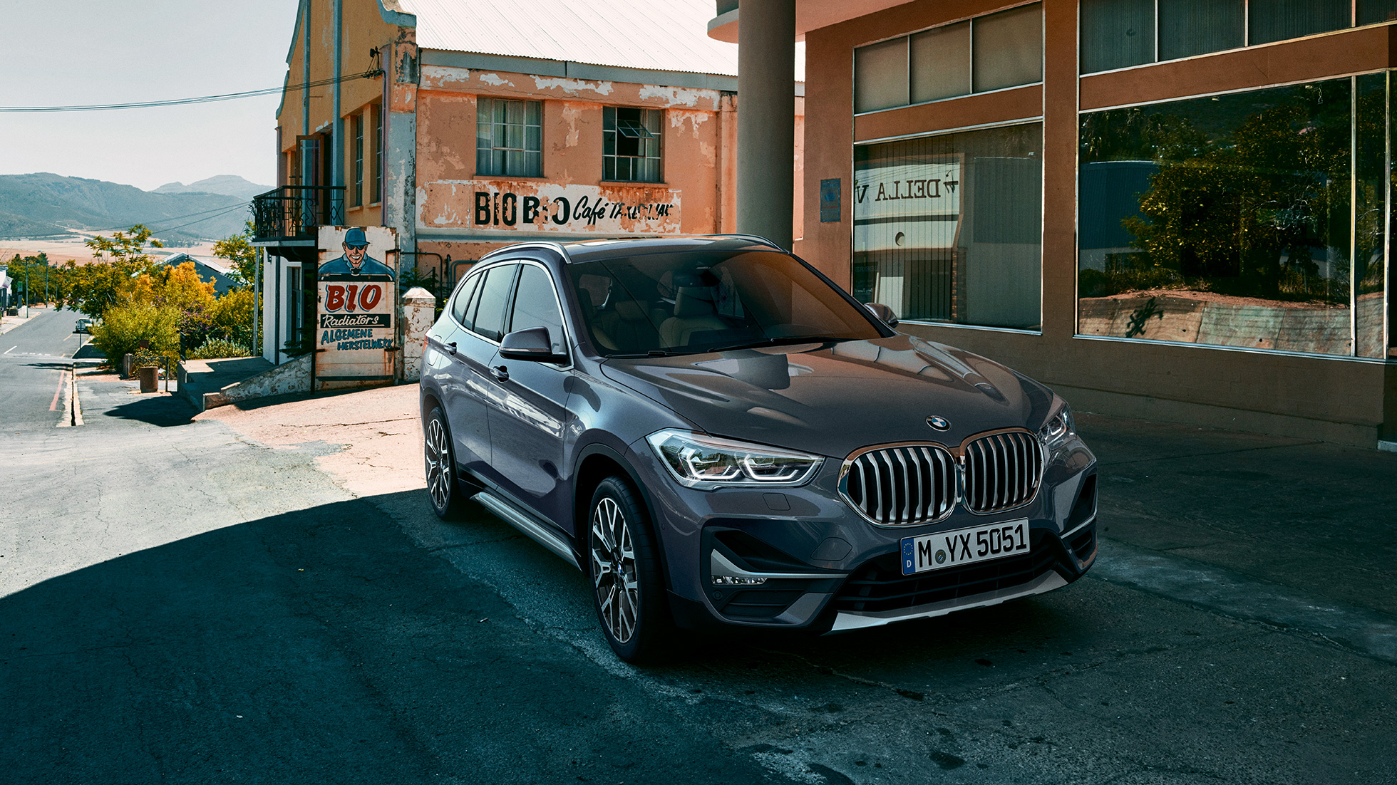 BMW X1, tričetrtinski pogled od spredaj. BMW X1, tričetrtinski pogled od spredaj, stoji pred mestno pokrajino.