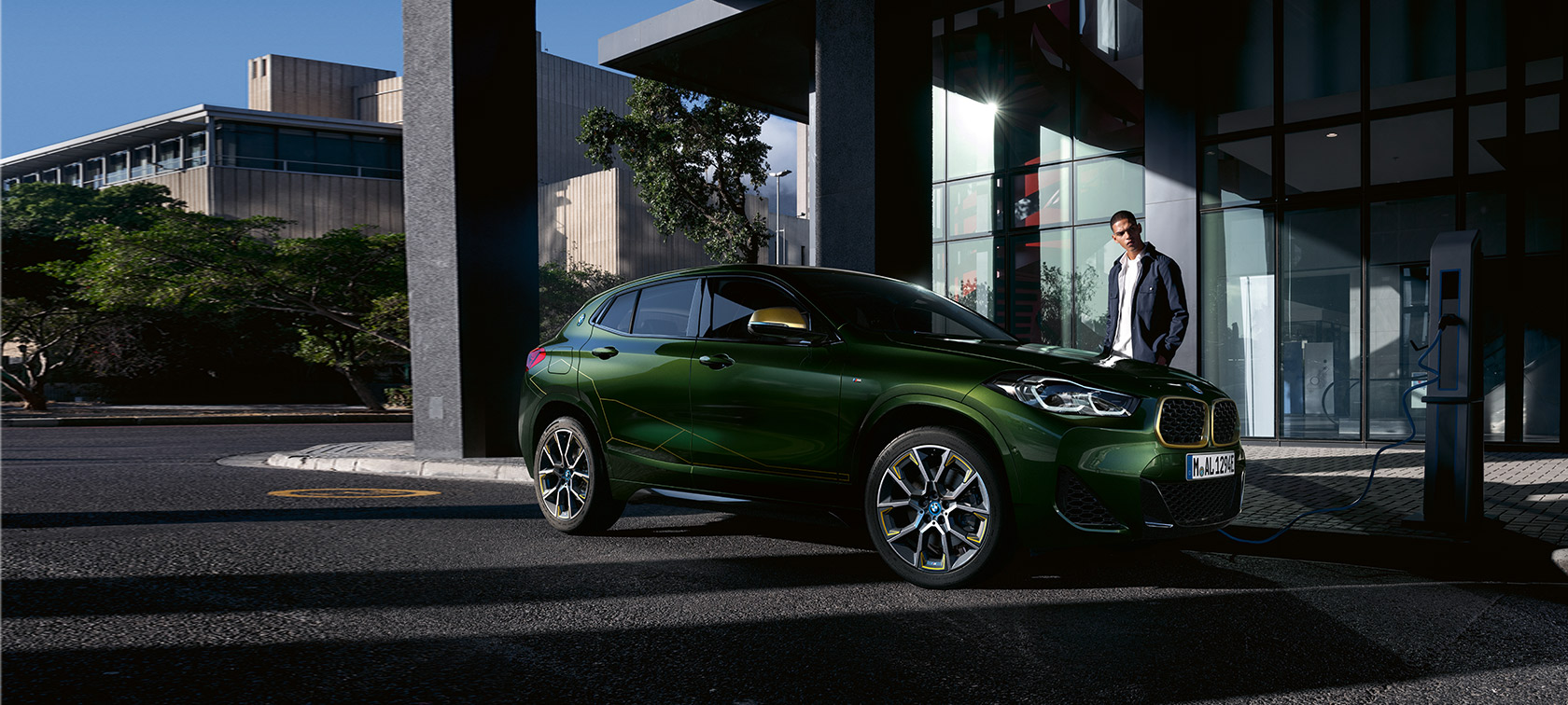 BMW X2, F39, kovinska barva Sanremo Green, tričetrtinski stranski pogled z manekenko BMW X2, F39, kovinska barva Sanremo Green, tričetrtinski stranski pogled z manekenko
