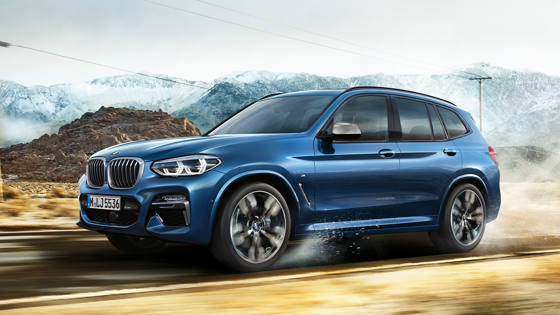 BMW X3 M40i, srednji plan platišča in sprednjega blatnika pred gorsko kuliso BMW X3 M40i, srednji plan platišča in sprednjega blatnika pred gorsko kuliso