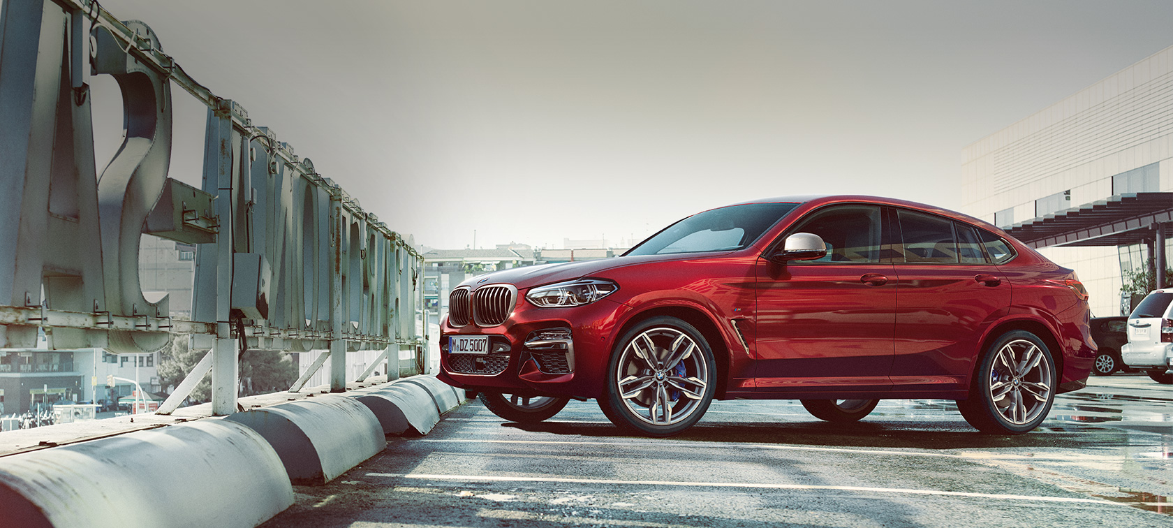 Stranski pogled med parkiranjem BMW X4 BMW X4 M40i G02 2018, Flamenco Red z briljantnim učinkom, stranski pogled med parkiranjem na parkirni ploščadi