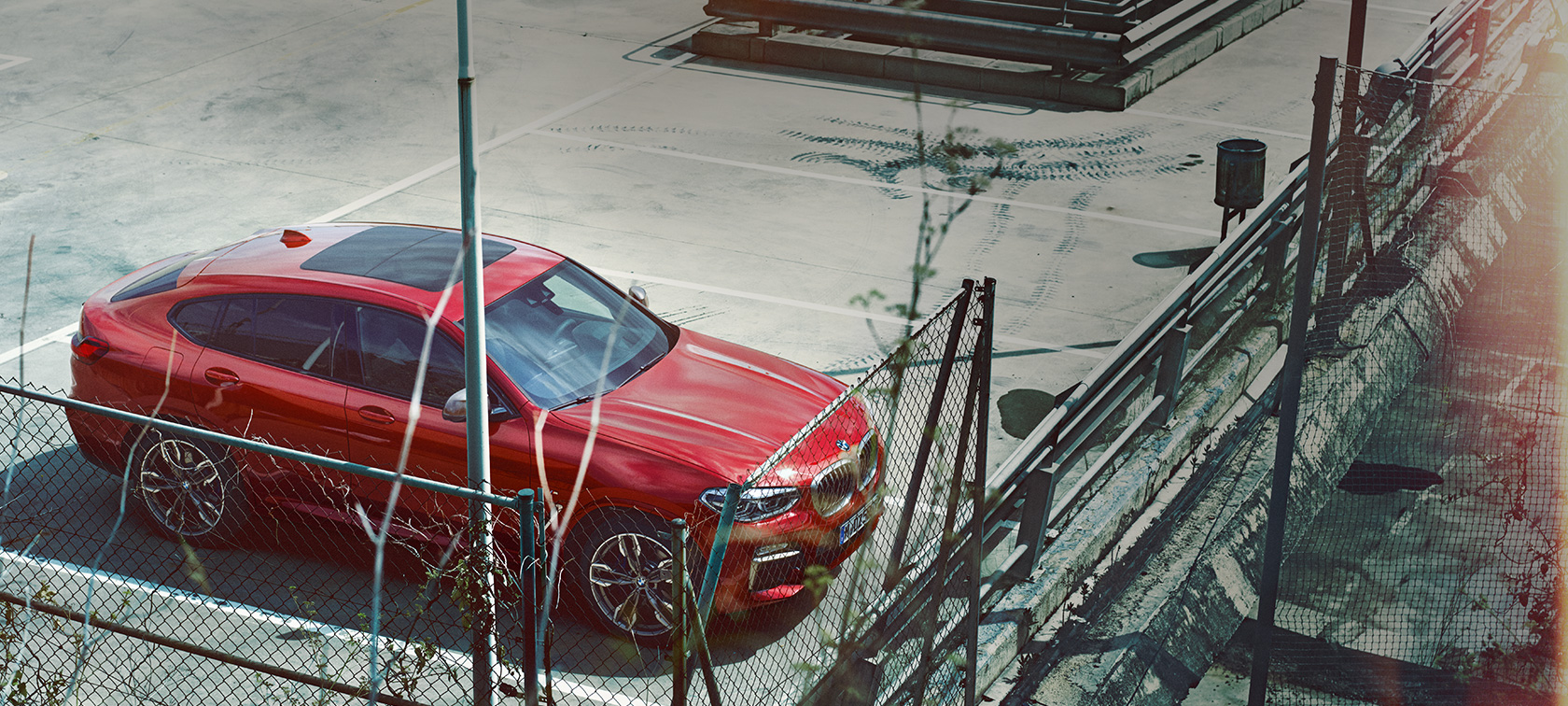 BMW X4 med parkiranjem BMW X4 G02 2018, Flamenco Red z briljantnim učinkom, pogled s ptičje perspektive med parkiranjem na parkirni ploščadi