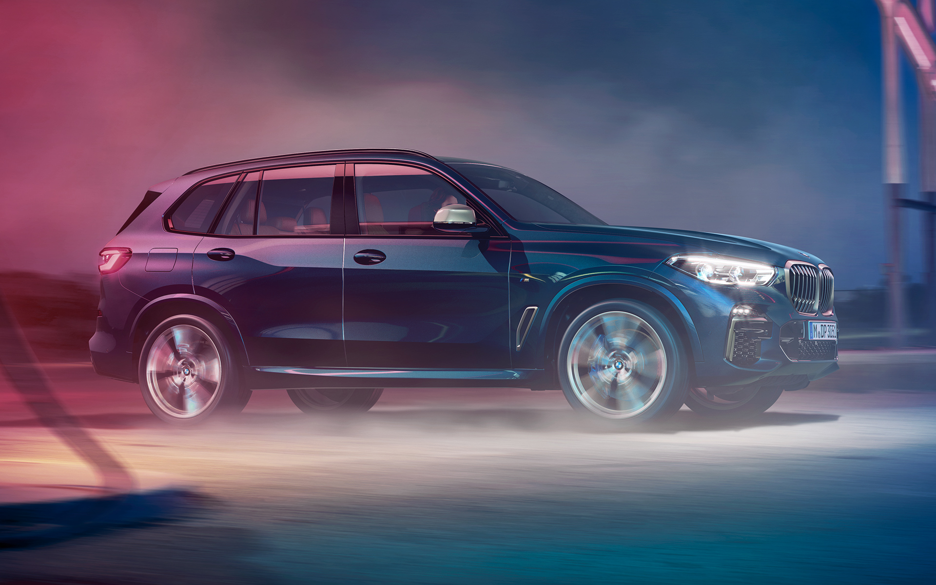 Vozilo BMW X5 M50d med vožnjo Fotografija vozila BMW X5 med vožnjo ponoči v mestnem okolju