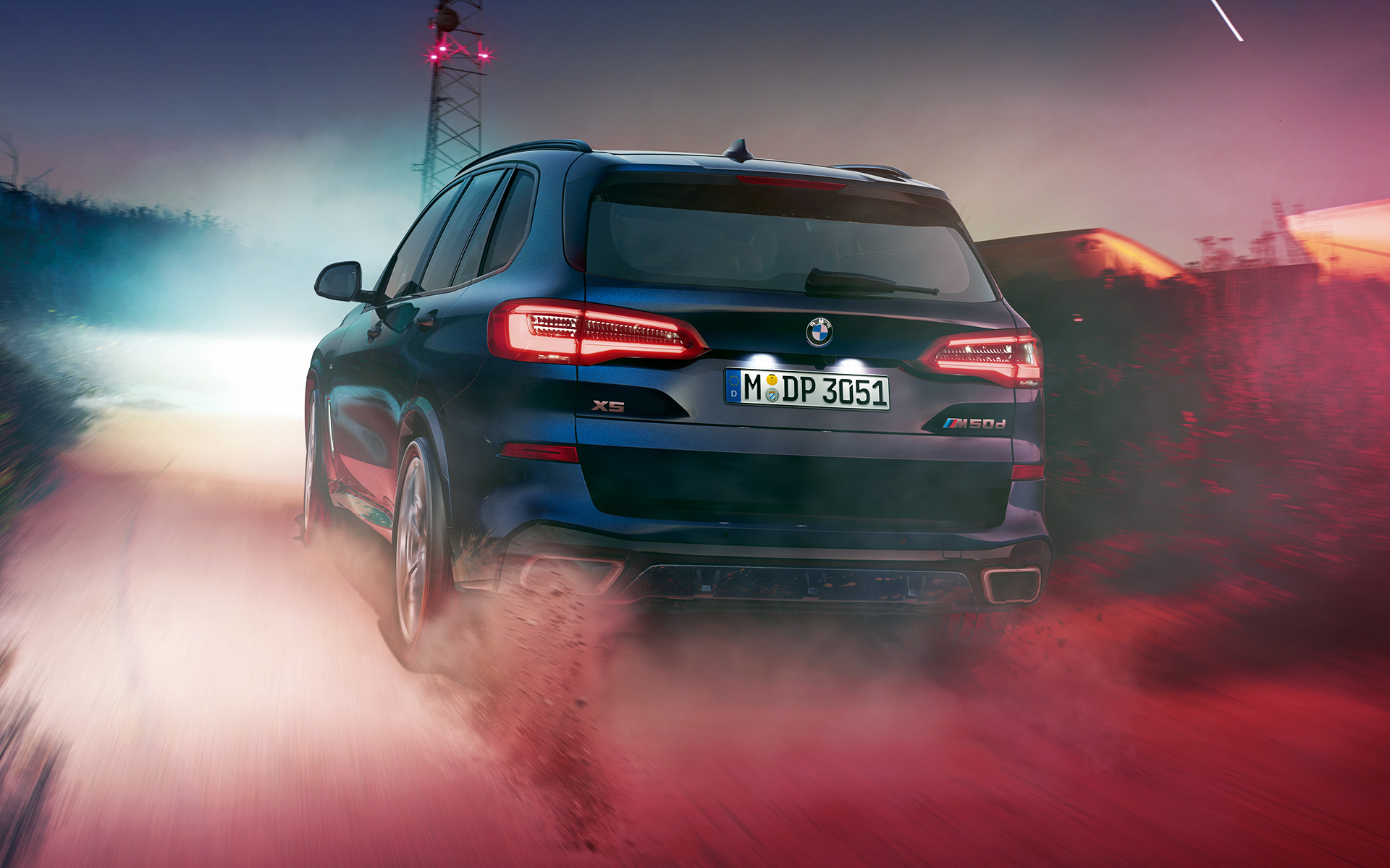 Zadek vozila BMW X5 M50d Zadek vozila BMW X5 med vožnjo ponoči v mestnem okolju