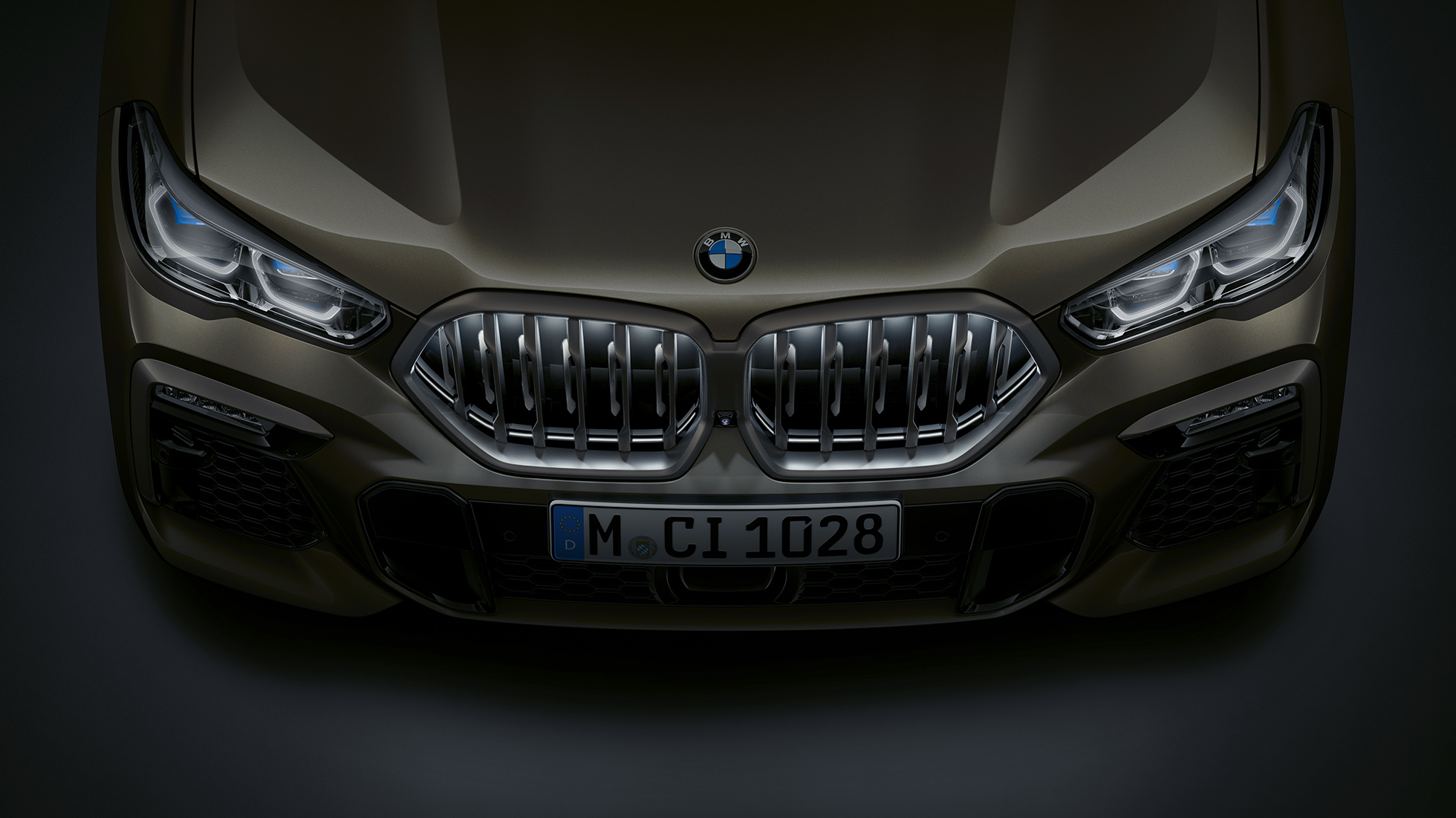 Sprednji del BMW X6. Pogled od blizu na sprednji del BMW X6 z ledvičko BMW Iconic Glow iz ptičje perspektive.