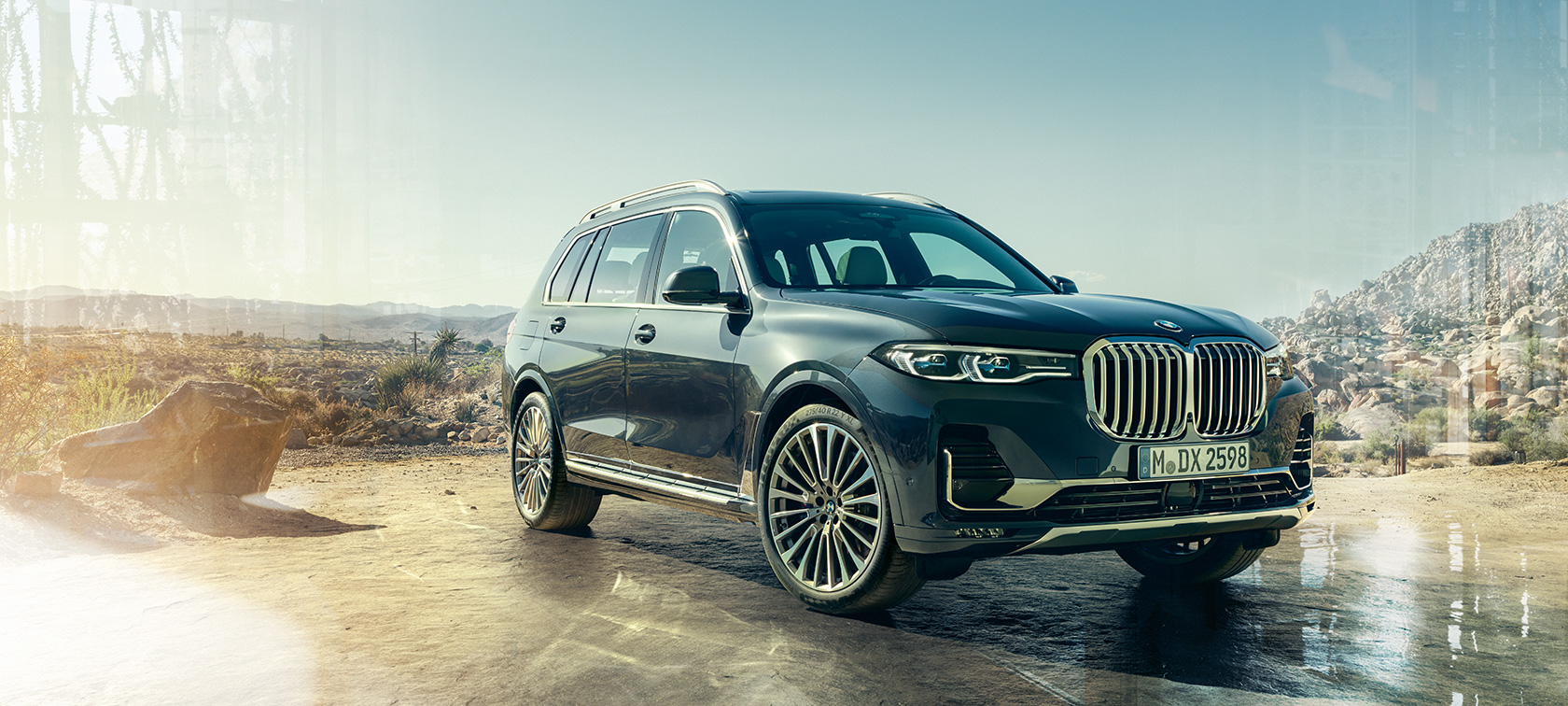BMW X7, tričetrtinski pogled od spredaj BMW X7 v barvi Arctic Grey, tričetrtinski pogled od spredaj pred puščavskim ozadjem, G07 2019