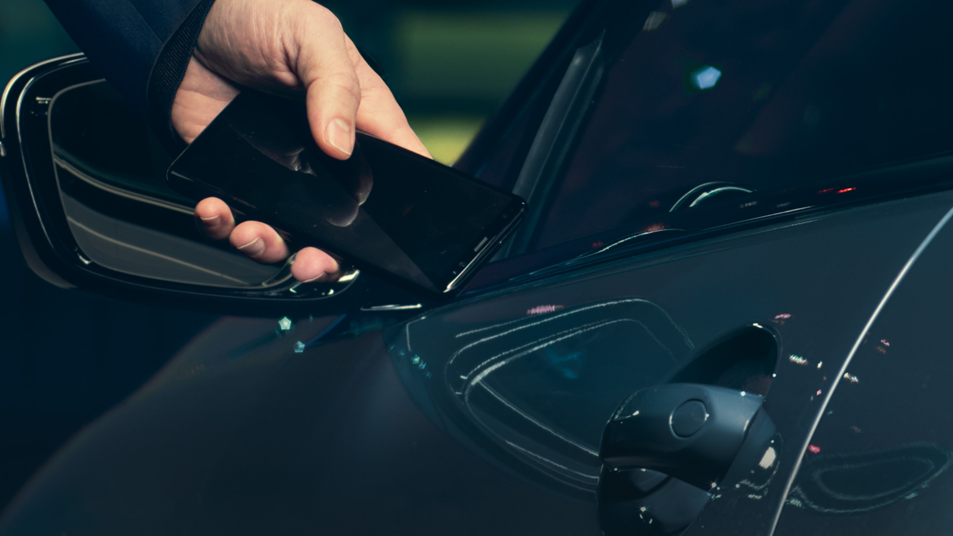 Digital Key Digital Key: moški drži svoj pametni telefon na vratih vozila od zunaj