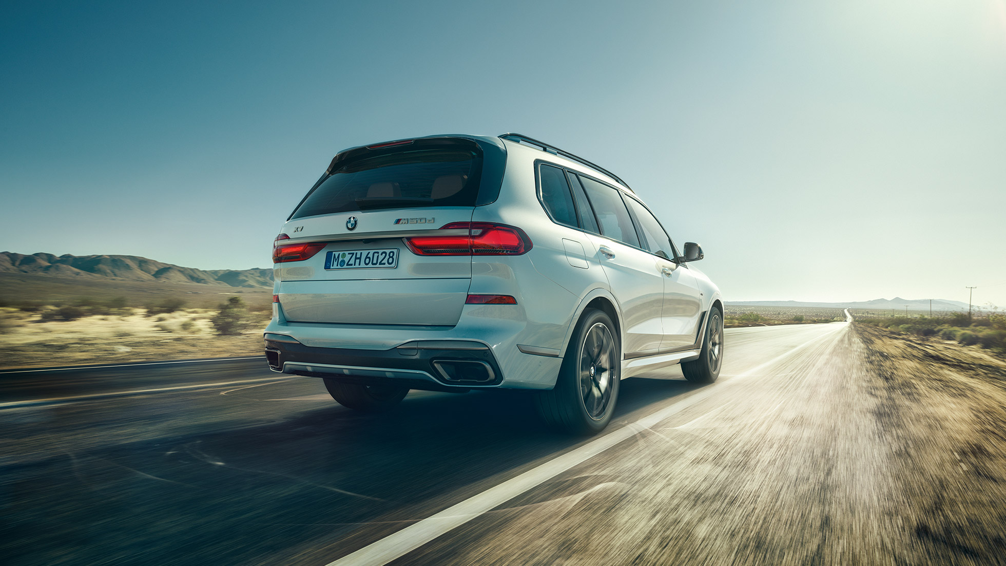 BMW X7 M50d, posnetek zadka BMW X7 M50d: posnetek zadka belega BMW X7 med vožnjo