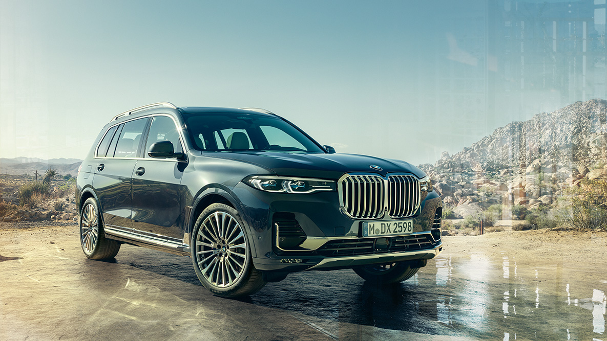 Zunanjost BMW X7, tričetrtinski pogled od spredaj Zunanjost BMW X7: tričetrtinski pogled od spredaj pred puščavskim ozadjem