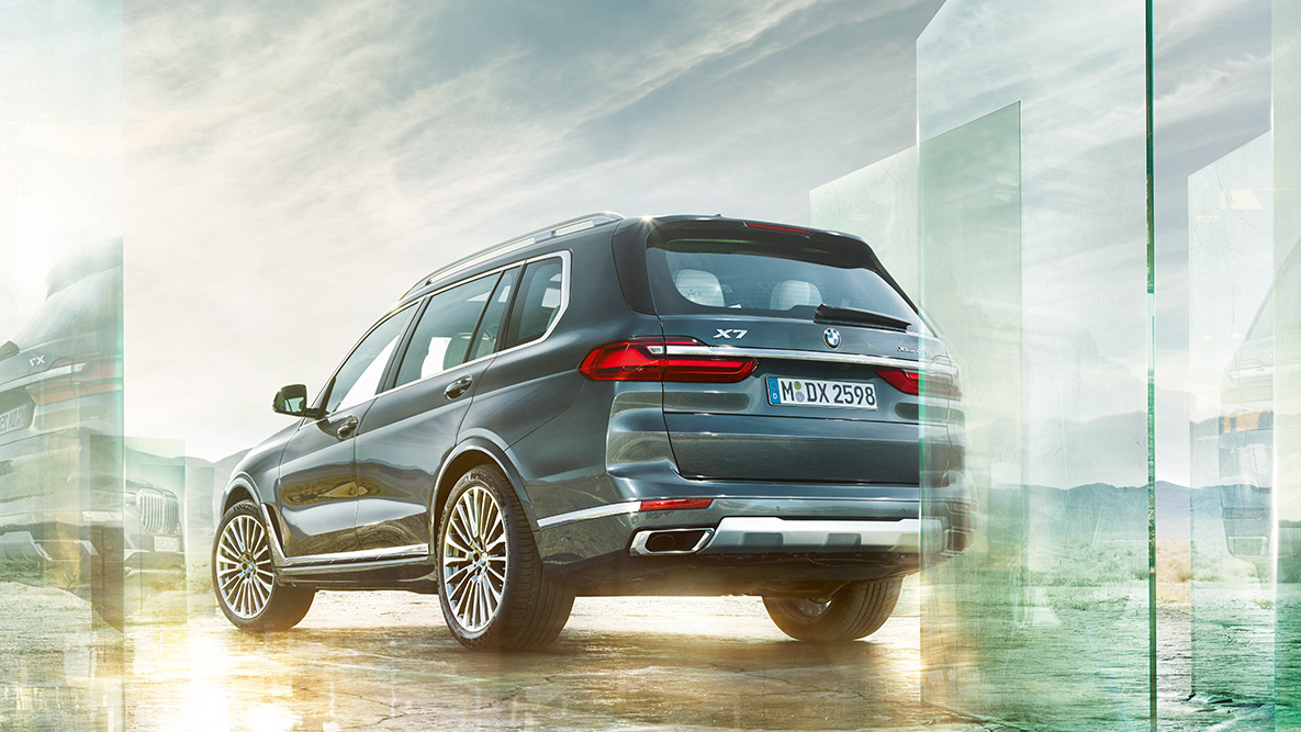 Udobje in dinamika vožnje vozila BMW X7 BMW X7 v tričetrtinskem pogledu na zadek pred abstraktnim ozadjem