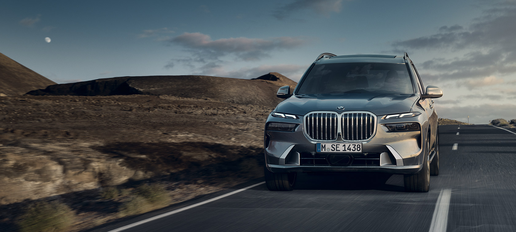 BMW X7 G07 LCI 7/8 Pogled od spredaj za vožnjo Svetleče bakreno siva kovinska