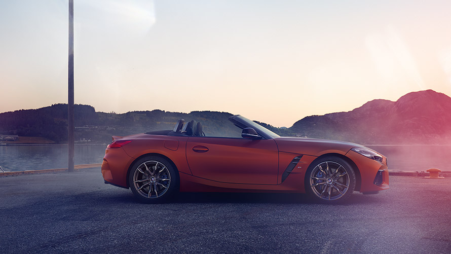 Rdeč BMW Z4 First Edition, ki stoji v ovinku Rdeč BMW Z4 First Edition, ki stoji v ovinku pred gorsko pokrajino