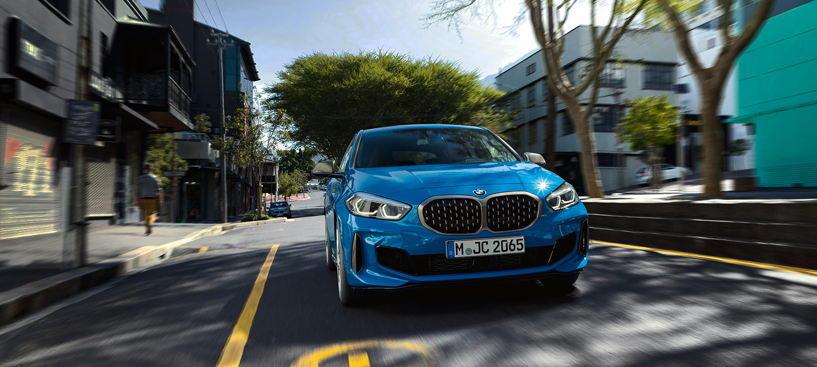 BMW serije 1 v kovinski barvi Misano Blue, pogled od spredaj med vožnjo.