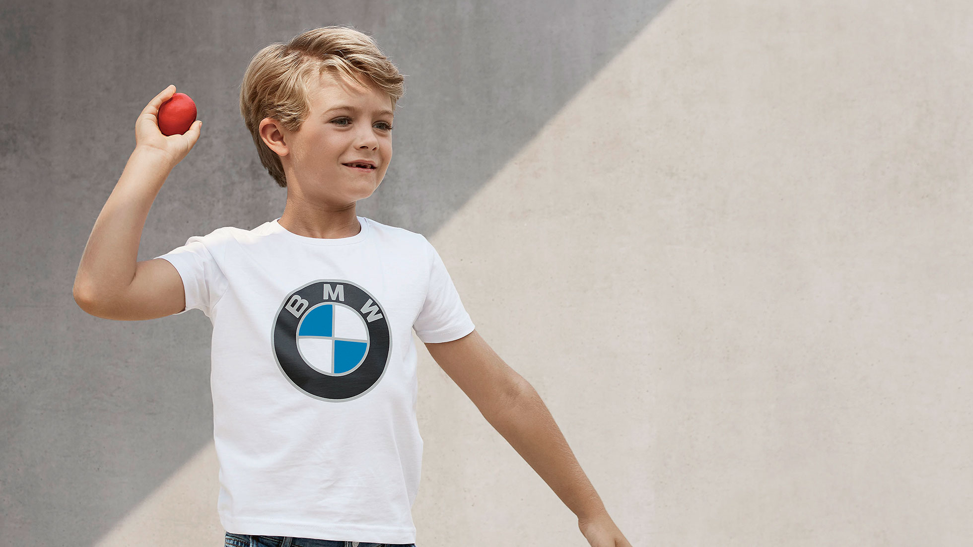 Kolekcija BMW Kids. Deček nosi oblačila iz kolekcije BMW Kids.