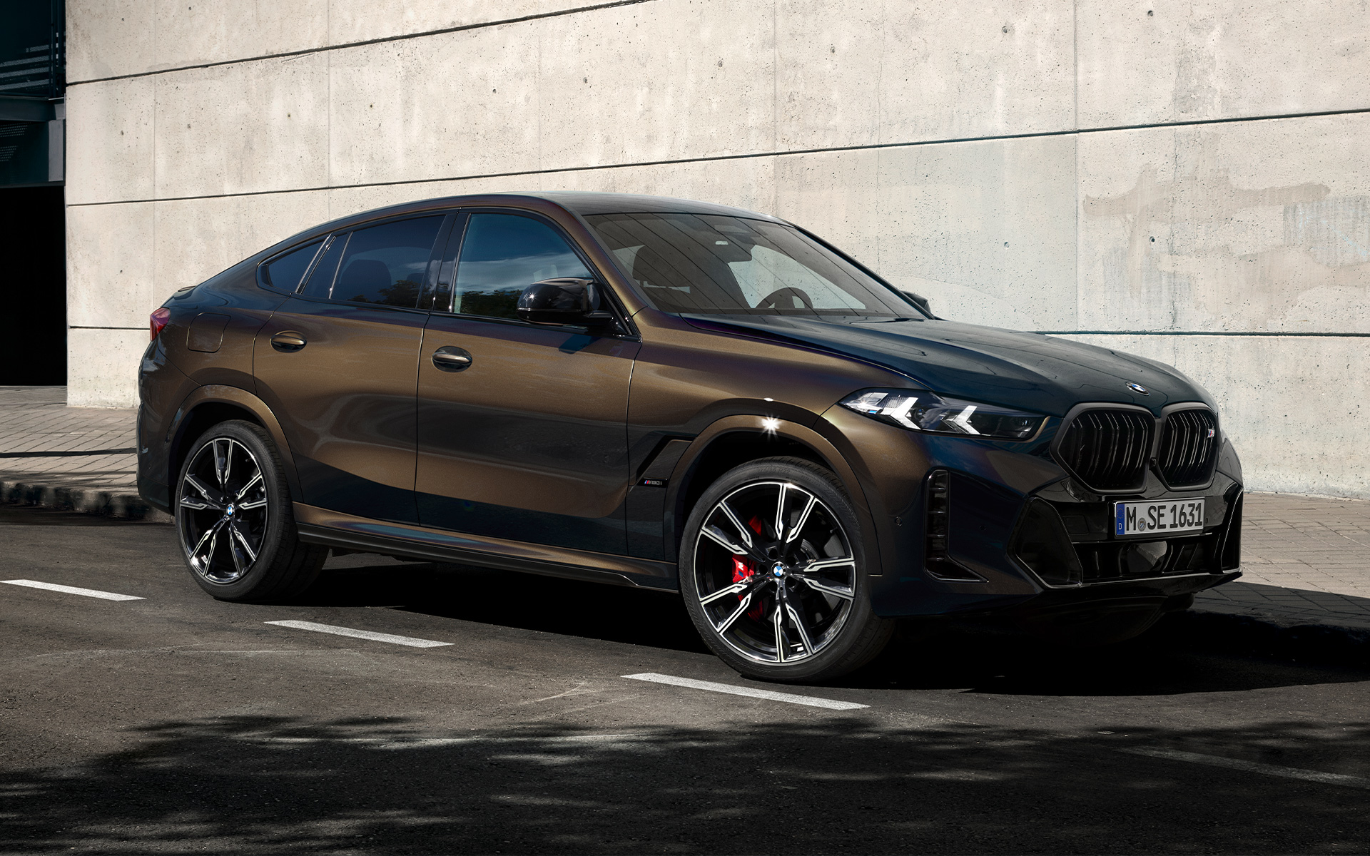 BMW X6 M60i, G06, kovinska barva Pyrite Brown BMW X6 M60i, G06, lakiranje BMW Individual v kovinski barvi Pyrite Brown, dvotretjinski stranski pogled med mirovanjem na parkirišču
