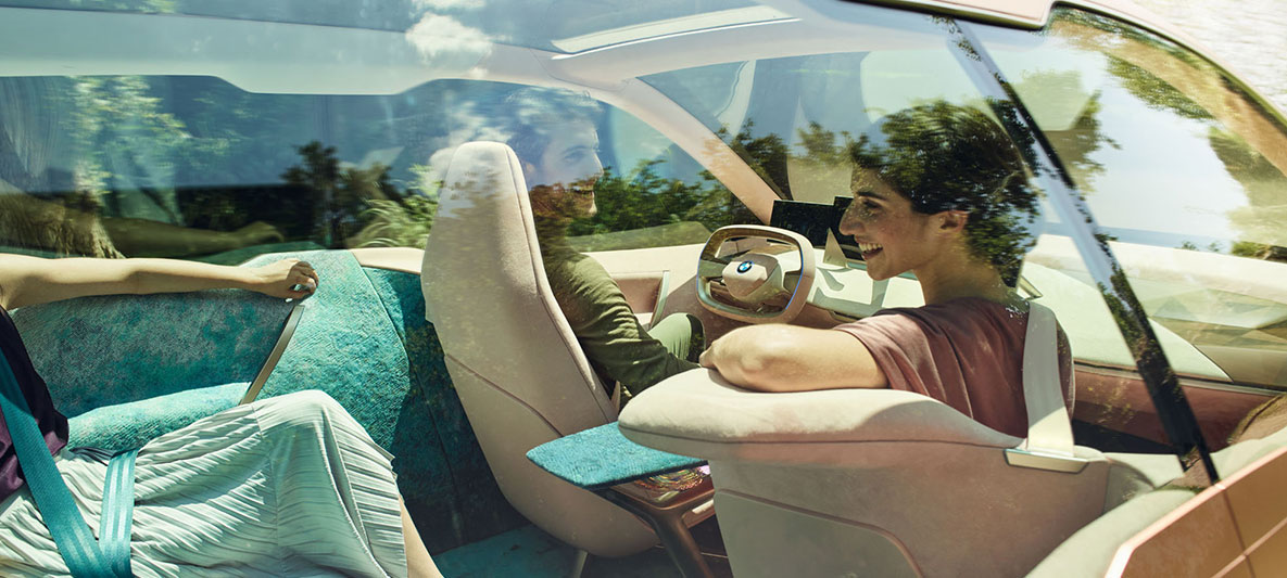 Notranjost avtomobila BMW Vision iNEXT Notranjost BMW Vision Inext z žensko, obrnjeno proti zadnjim sedežem