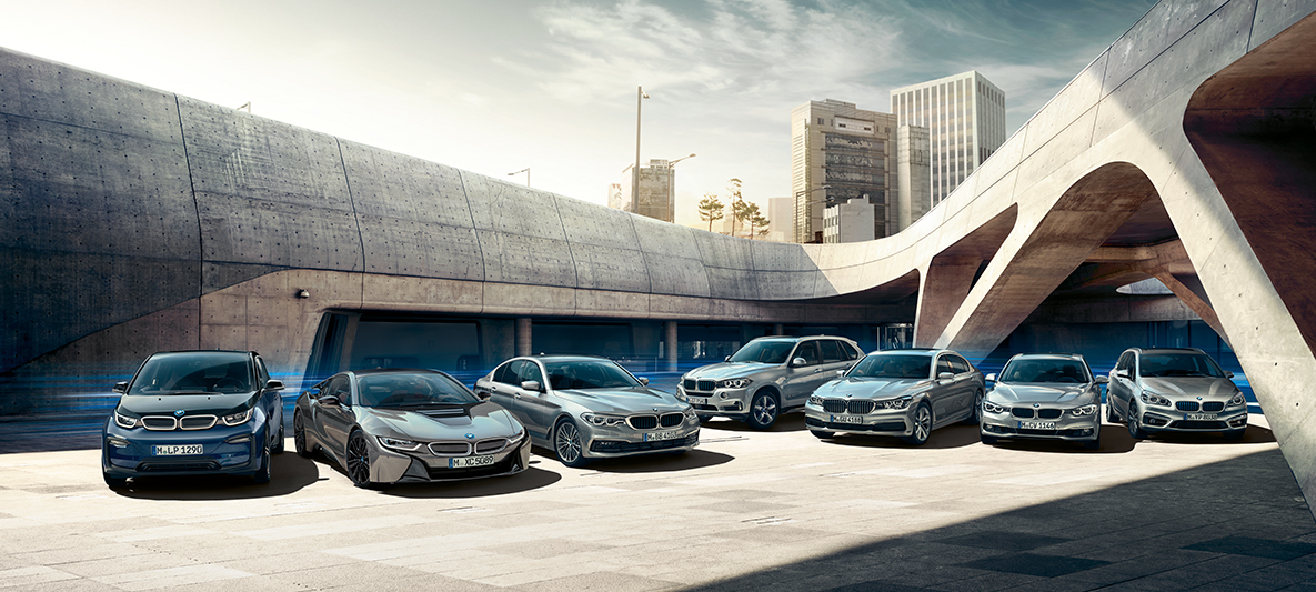 Električni avtomobili in hibridna vozila BMW pred stavbami Elektromobilnost BMW, možnosti, električni avtomobili in hibridna vozila BMW pred stavbami