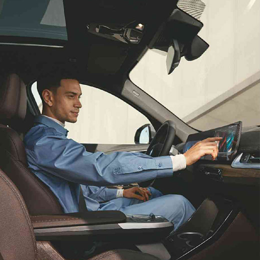 Connected Charging na krovu BMW, moški upravlja ukrivljeni zaslon BMW