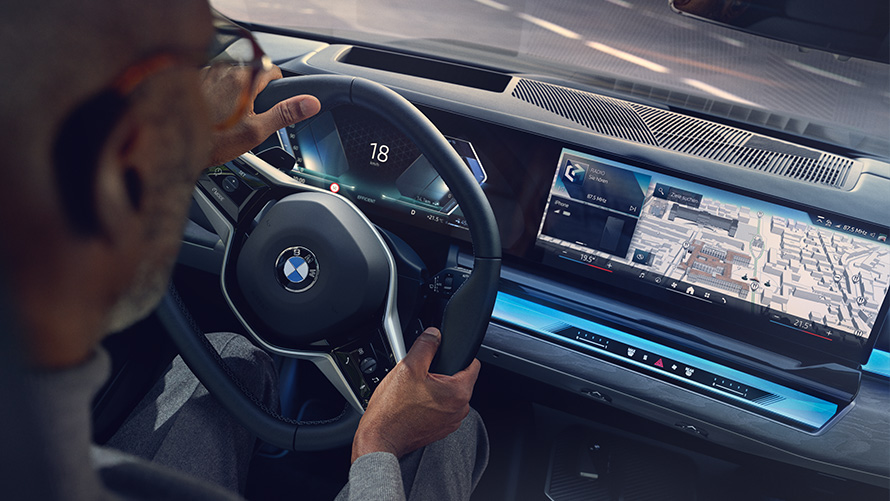 Notranjost BMW, moški gleda na zaslon z Operating System 8.5 Notranjost BMW, moški si ogleduje BMW Maps na zaslonu z Operating System 8.5