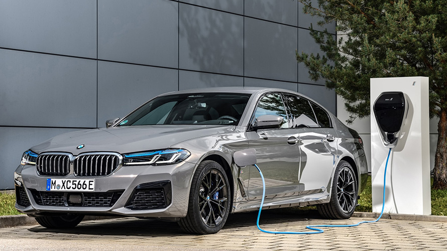 BMW Remote Software Upgrade, hibridno vozilo BMW pred polnilno postajo BMW Remote Software Upgrade, hibridno vozilo BMW pred polnilno postajo, tričetrtinski pogled od spredaj