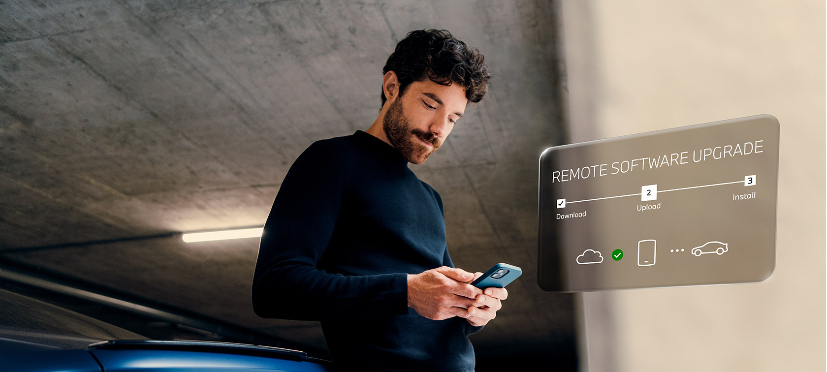 Moški pred BMW gleda svoj pametni telefon Remote Software Upgrade, moški pred BMW gleda svoj pametni telefon