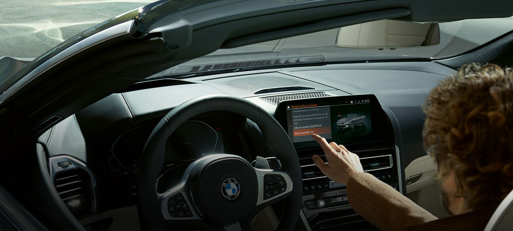 BMW Remote Software Upgrade Moški sedi v BMW in zažene BMW Remote Software Upgrade