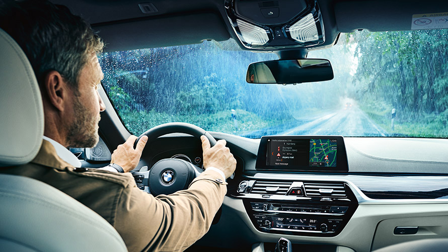 Real Time Traffic Information Moški uporablja Real Time Traffic Information na zaslonu v BMW