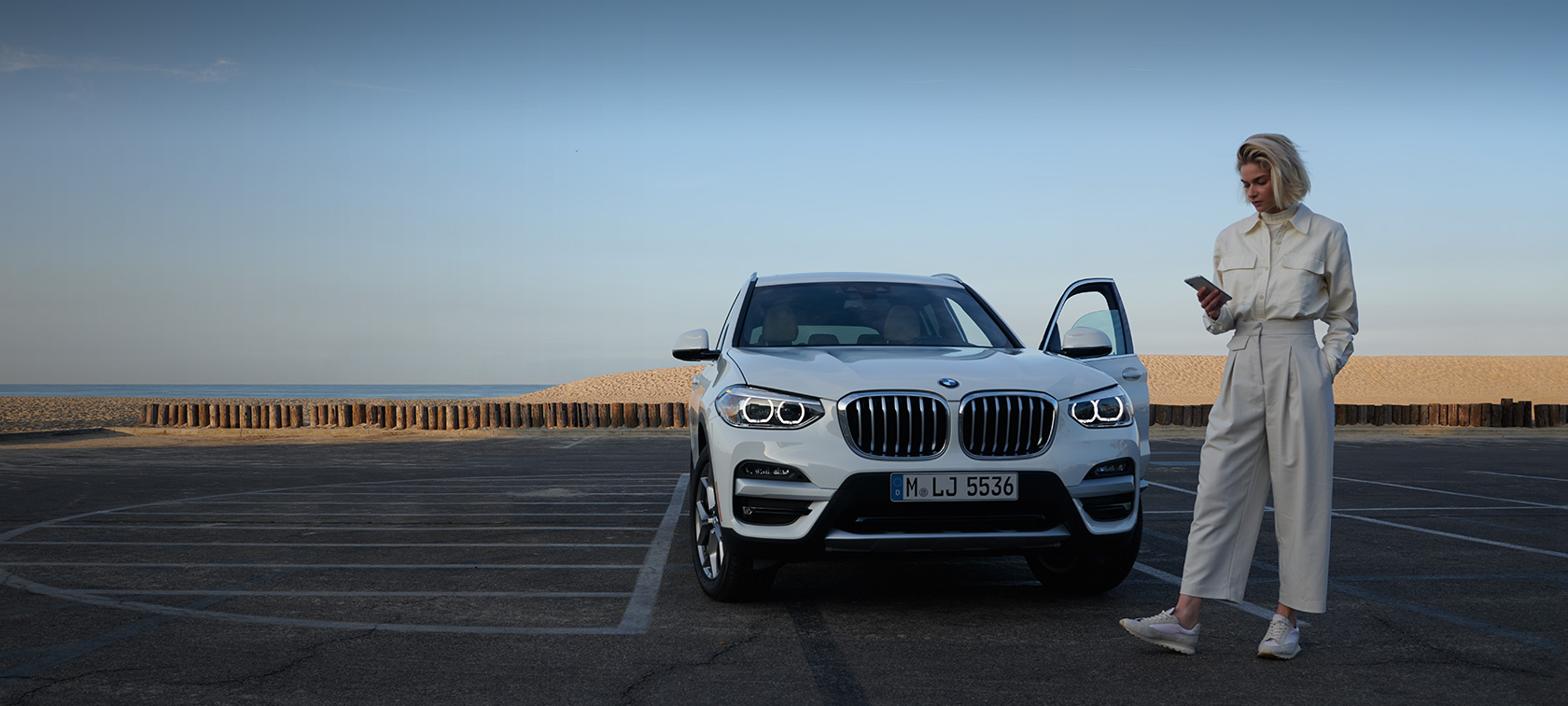 Ženska uporablja aplikacijo My BMW na pametnem telefonu Ženska uporablja aplikacijo My BMW na pametnem telefonu