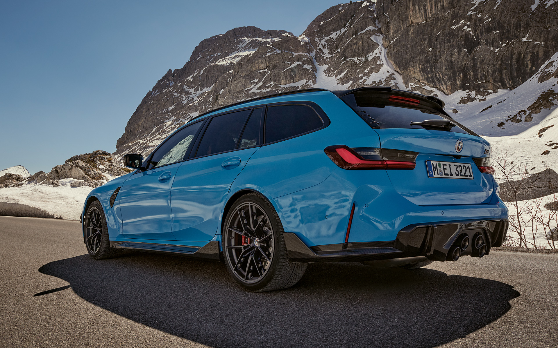 BMW M3 Touring, G81, BMW M Performance deli in dodatna oprema, tričetrtinski stranski pogled med vožnjo BMW M3 Touring, G81, BMW M Performance deli in dodatna oprema, tričetrtinski stranski pogled med vožnjo pred gorsko pokrajino