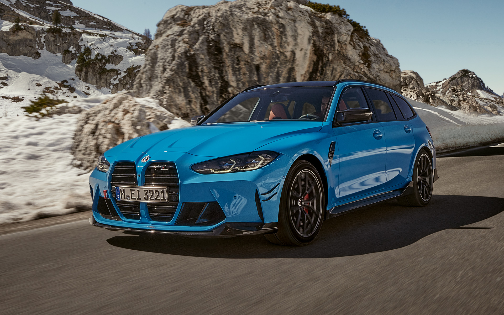 BMW M3 Touring, G81, BMW M Performance deli in dodatna oprema, tričetrtinski stranski pogled od spredaj med vožnjo BMW M3 Touring, G81, BMW M Performance deli in dodatna oprema, tričetrtinski pogled od spredaj med vožnjo pred gorsko pokrajino